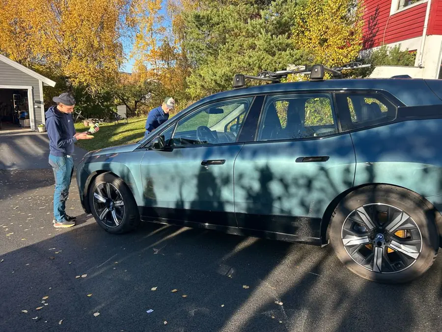 Petter og Jens jobber med bilen i høstsol